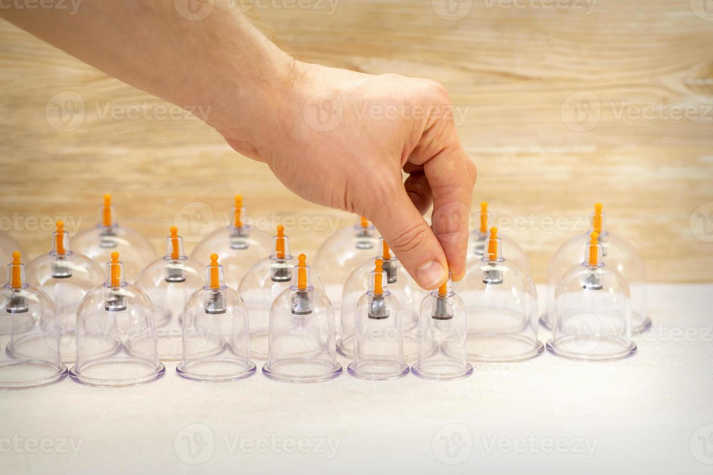 Massage therapist taking vacuum cups photo