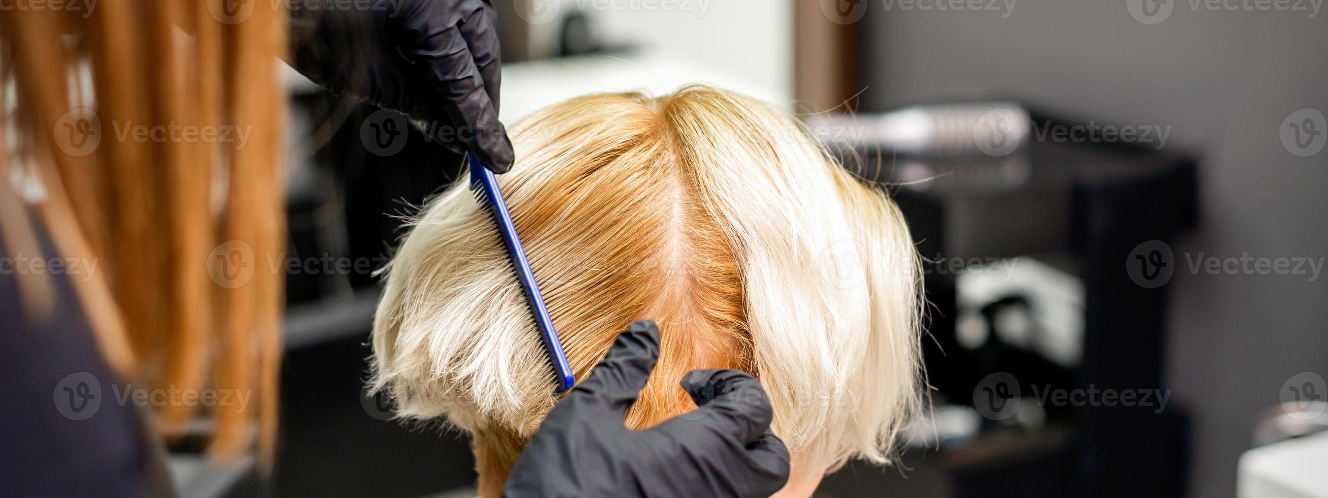 Hairdresser combing female short hair photo