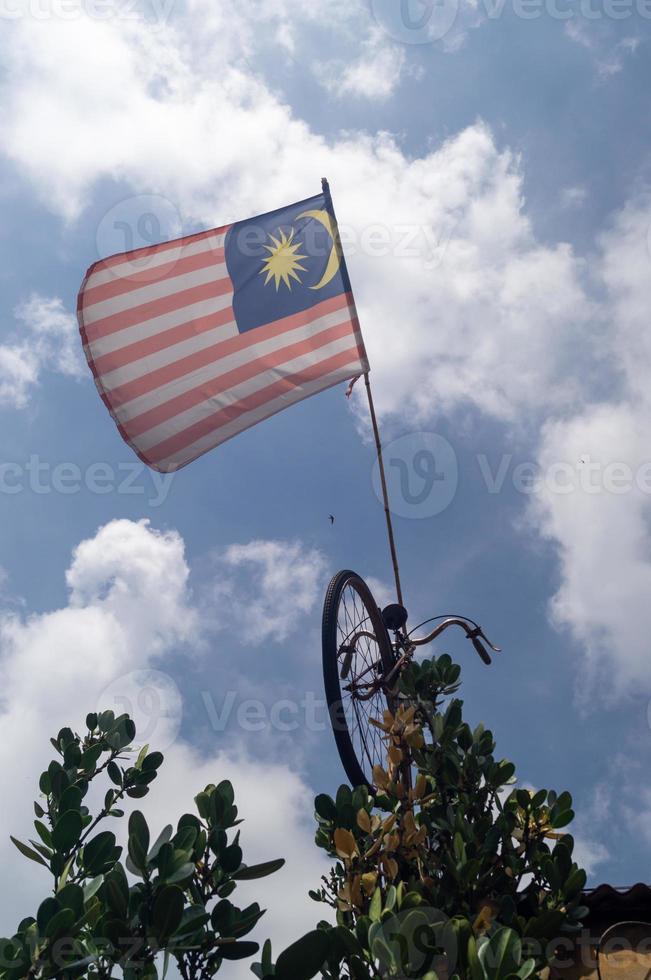 Malaysia flag hang on bicycle under blue sky photo