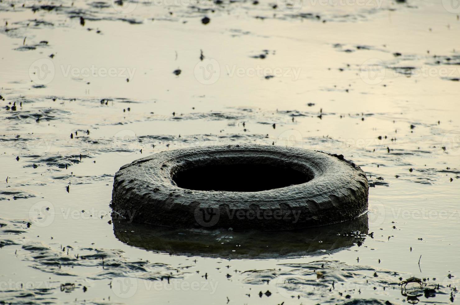 Old car tire in the mud photo