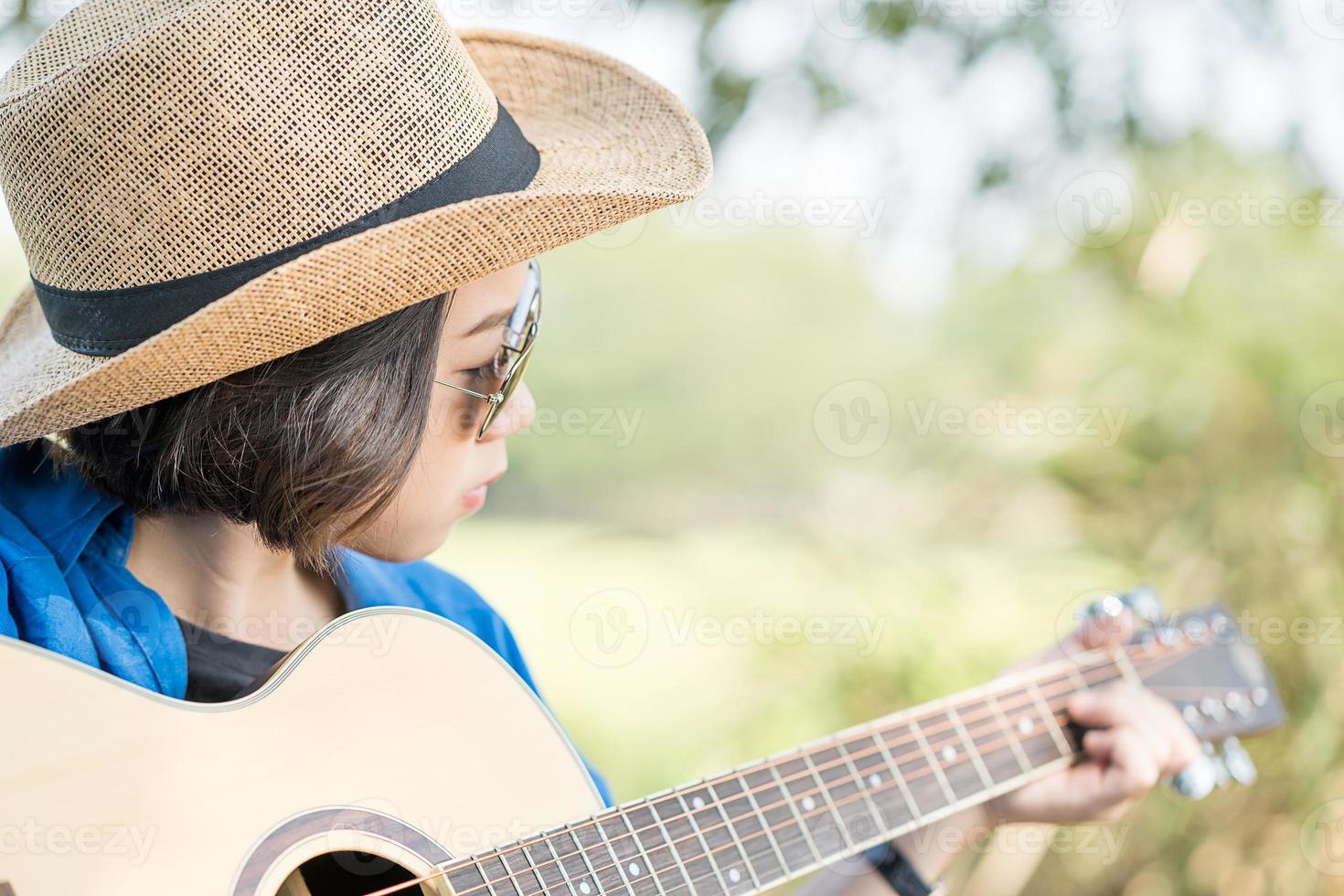 cerrar mujer usar sombrero y tocar la guitarra foto