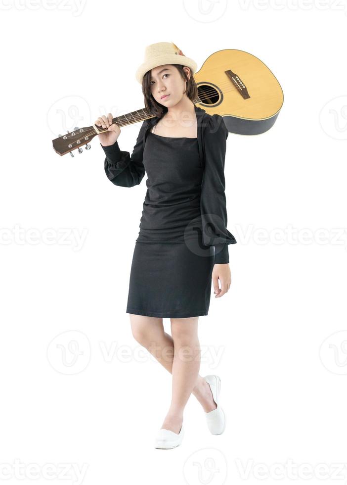 mujer cargando guitarra acustica al hombro foto