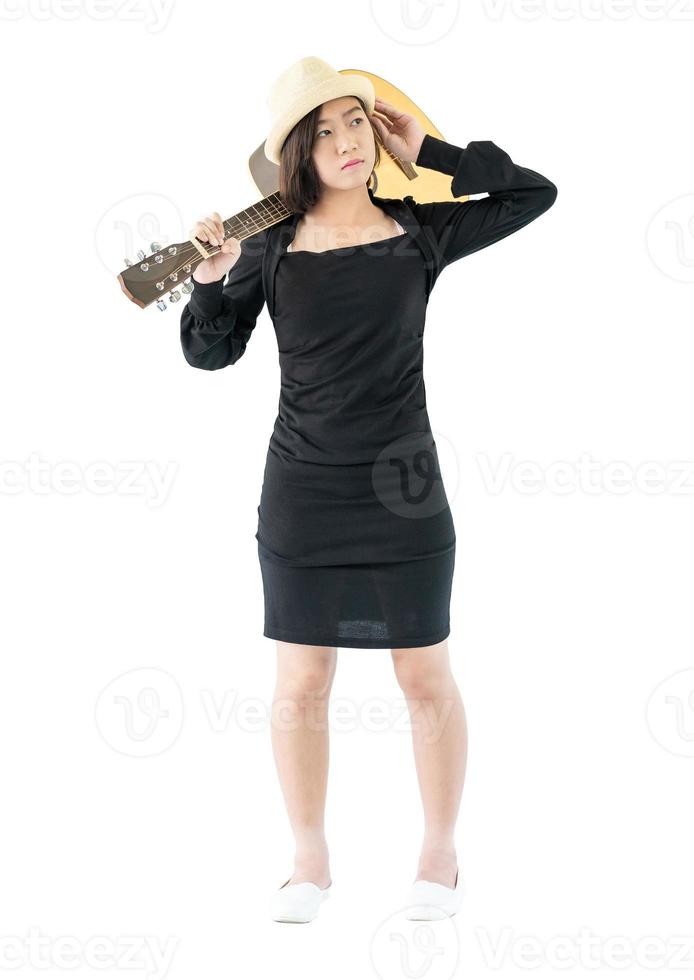 mujer cargando guitarra acustica al hombro foto