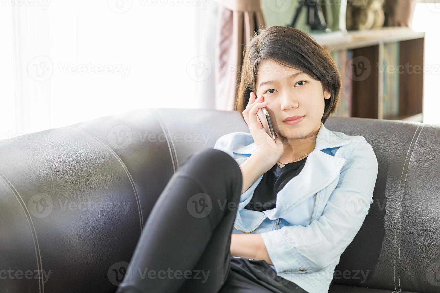 woman short hair use mobile phone on the couch photo