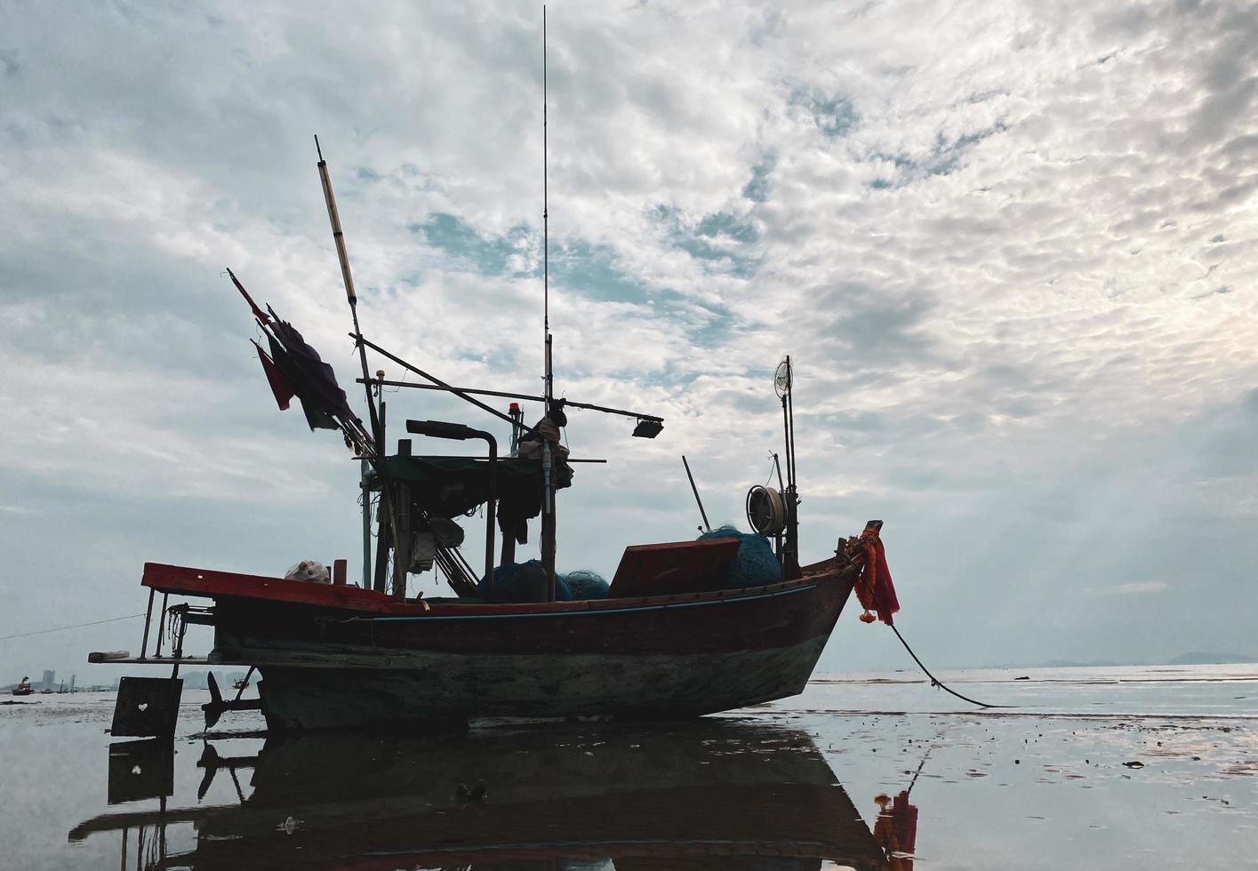 fishing boats during sunset sky at beach landscape, fishing boats during a sunrise or sunset, shimmering of the sun on the clouds,the sky and clouds have the power to inspire feelings of awe or wonder photo