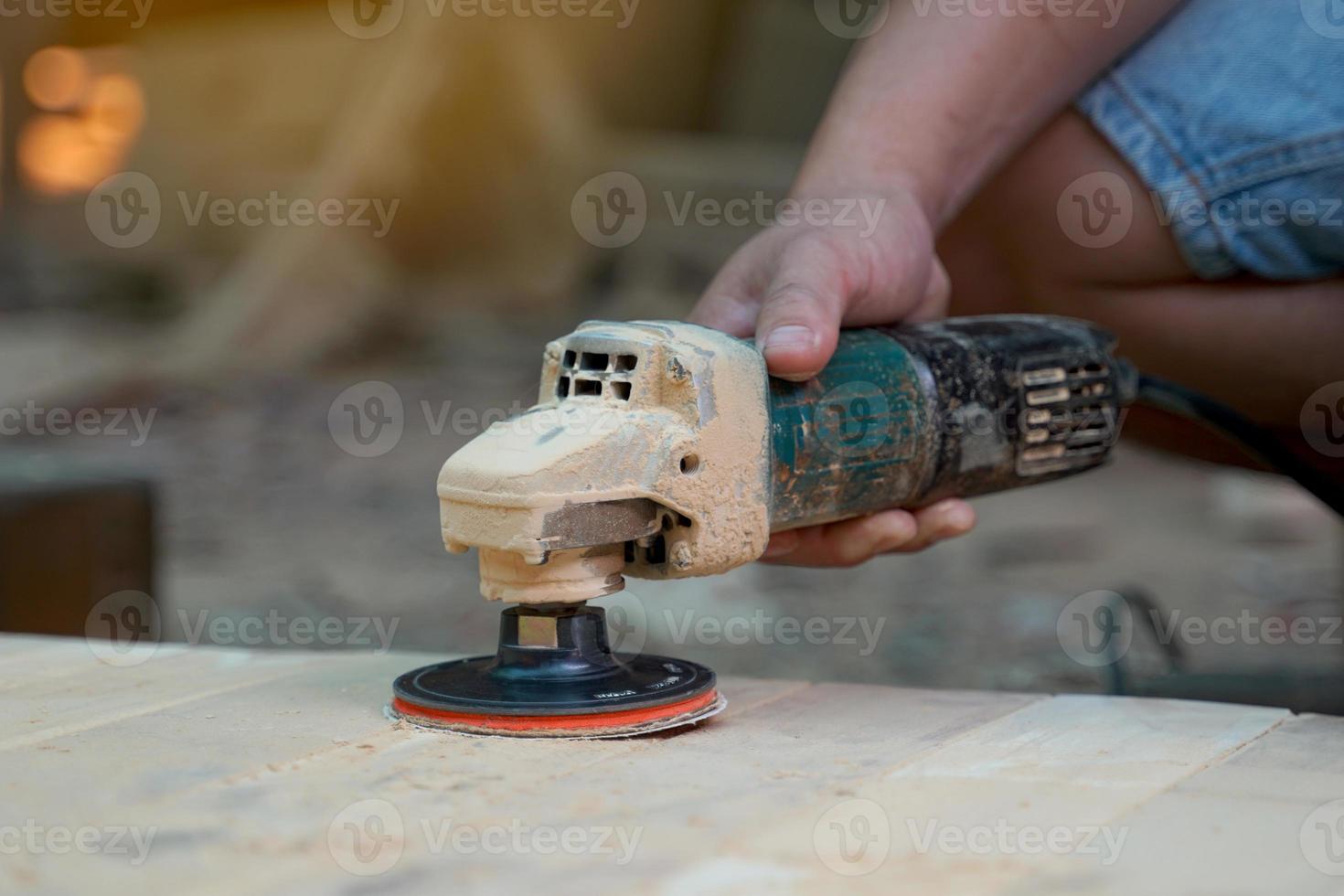 Carpenters use a sander to sand the surface of the wood to smooth the woodwork before painting. Soft and selective focus. photo