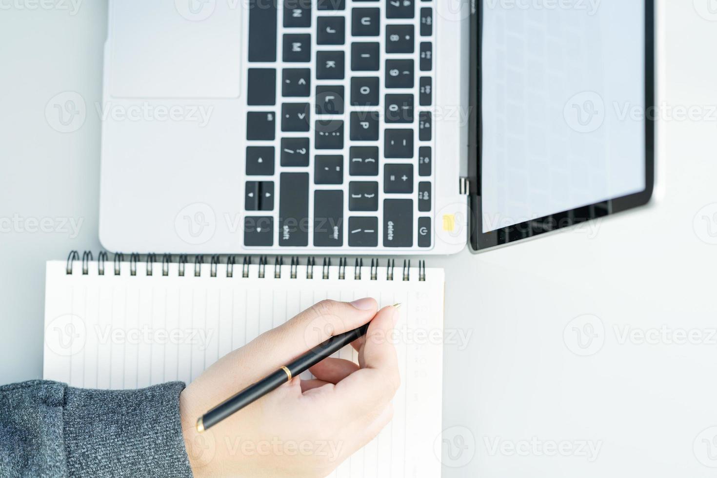 Woman working at home office using laptop searching web, browsing information photo