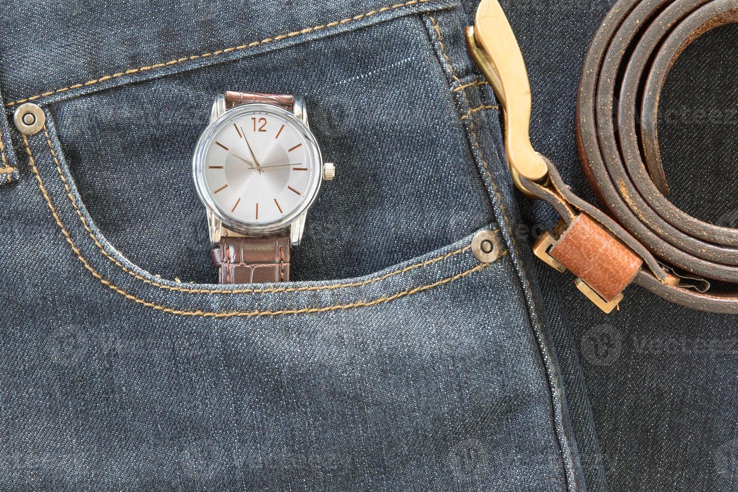 Wrist watch and leather belt on jeans photo