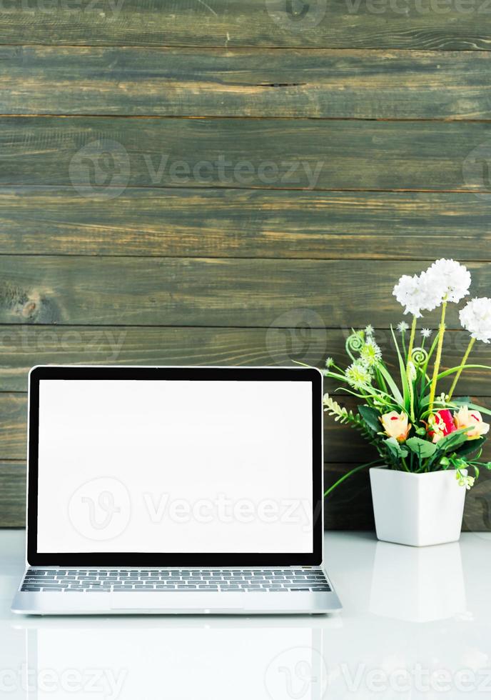 Laptop mockup with wood background on the work table photo