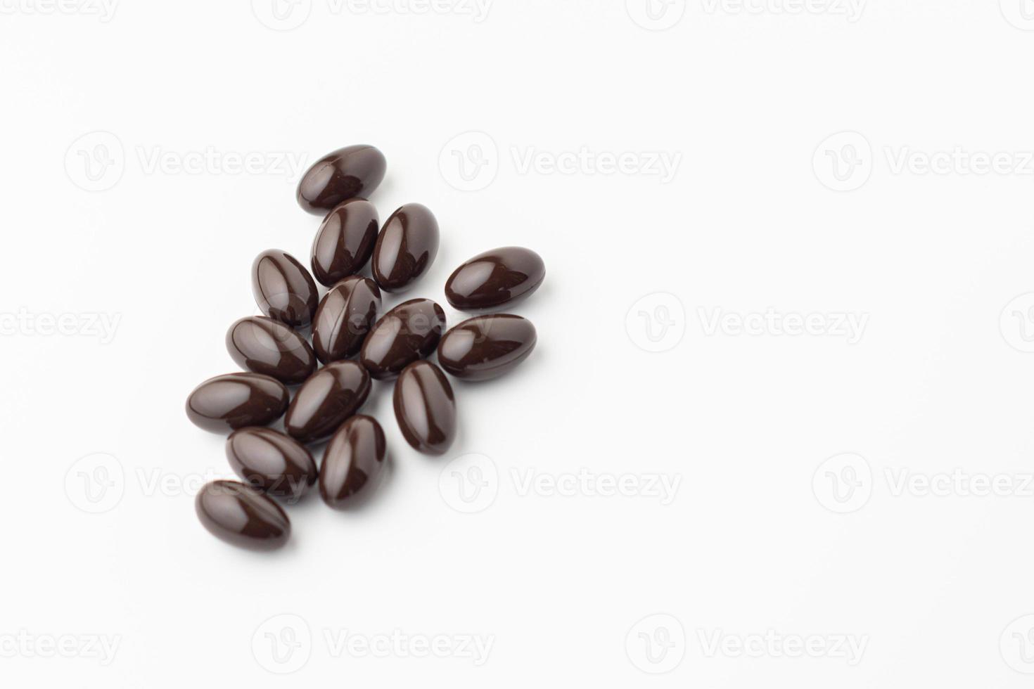 group of black soft gel capsules on a white background, Vitamin food supplements, Vitamin E dietary supplement photo