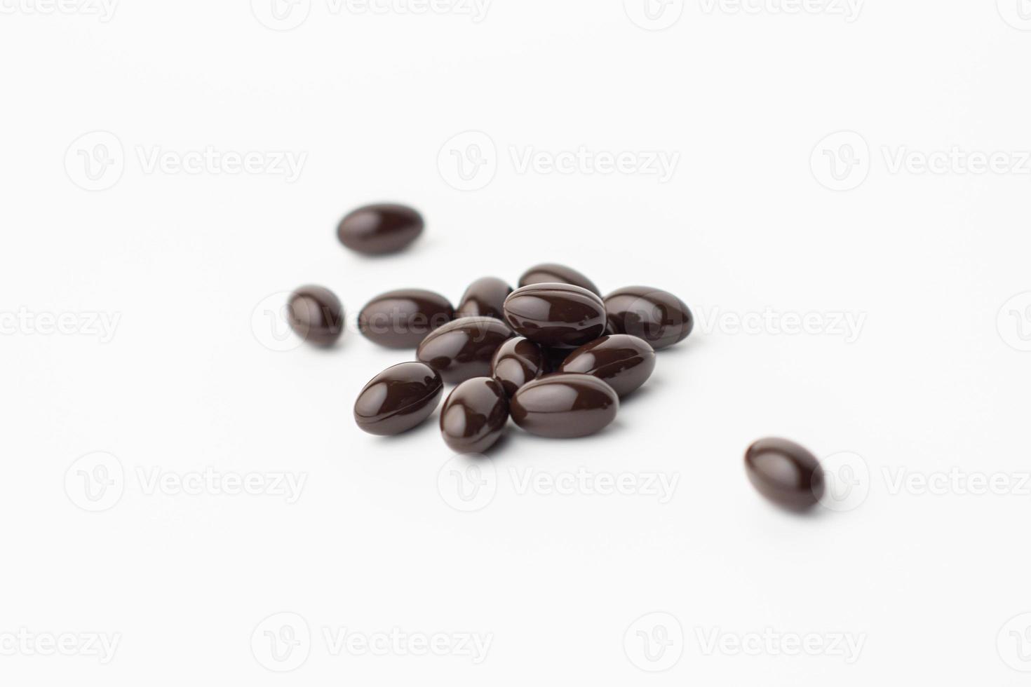 group of black soft gel capsules on a white background, Vitamin food supplements, Vitamin E dietary supplement photo