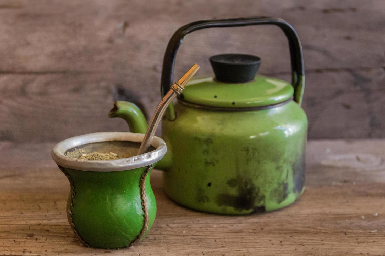 mate and kettle, traditional Argentine yerba mate infusion, on rustic wooden background photo