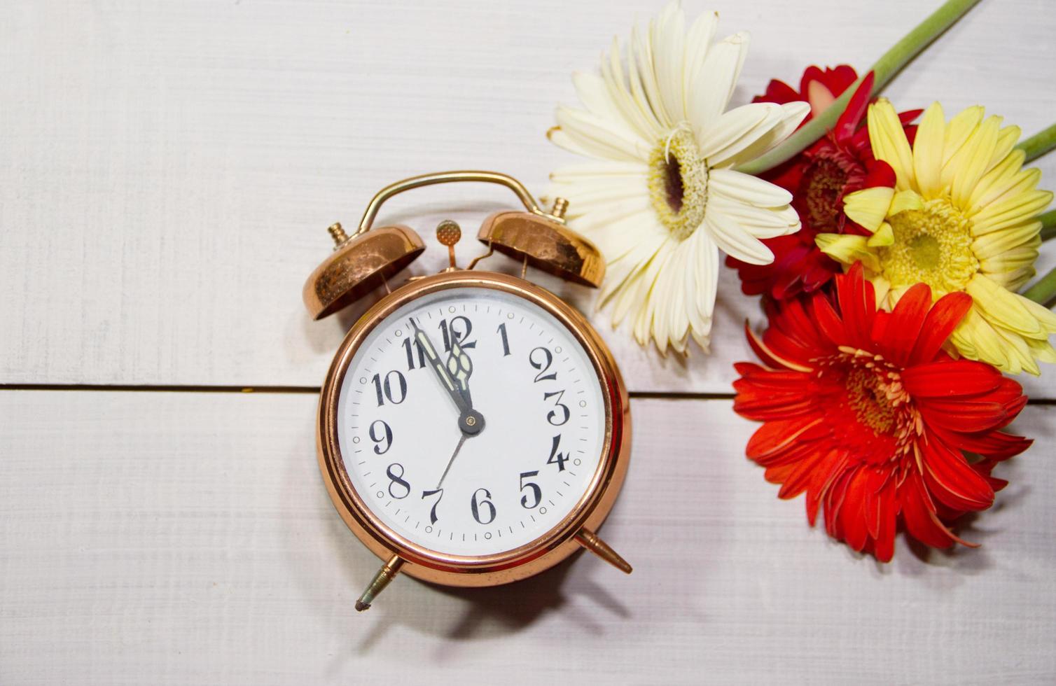 clock flowers and books concept of spring time and reading photo