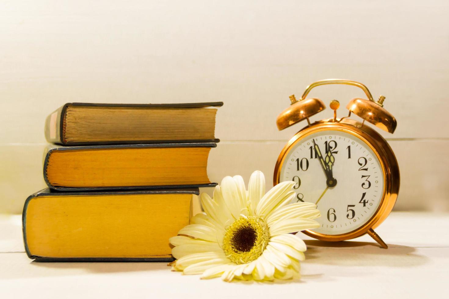 reloj flores y libros concepto de primavera hora y leyendo foto