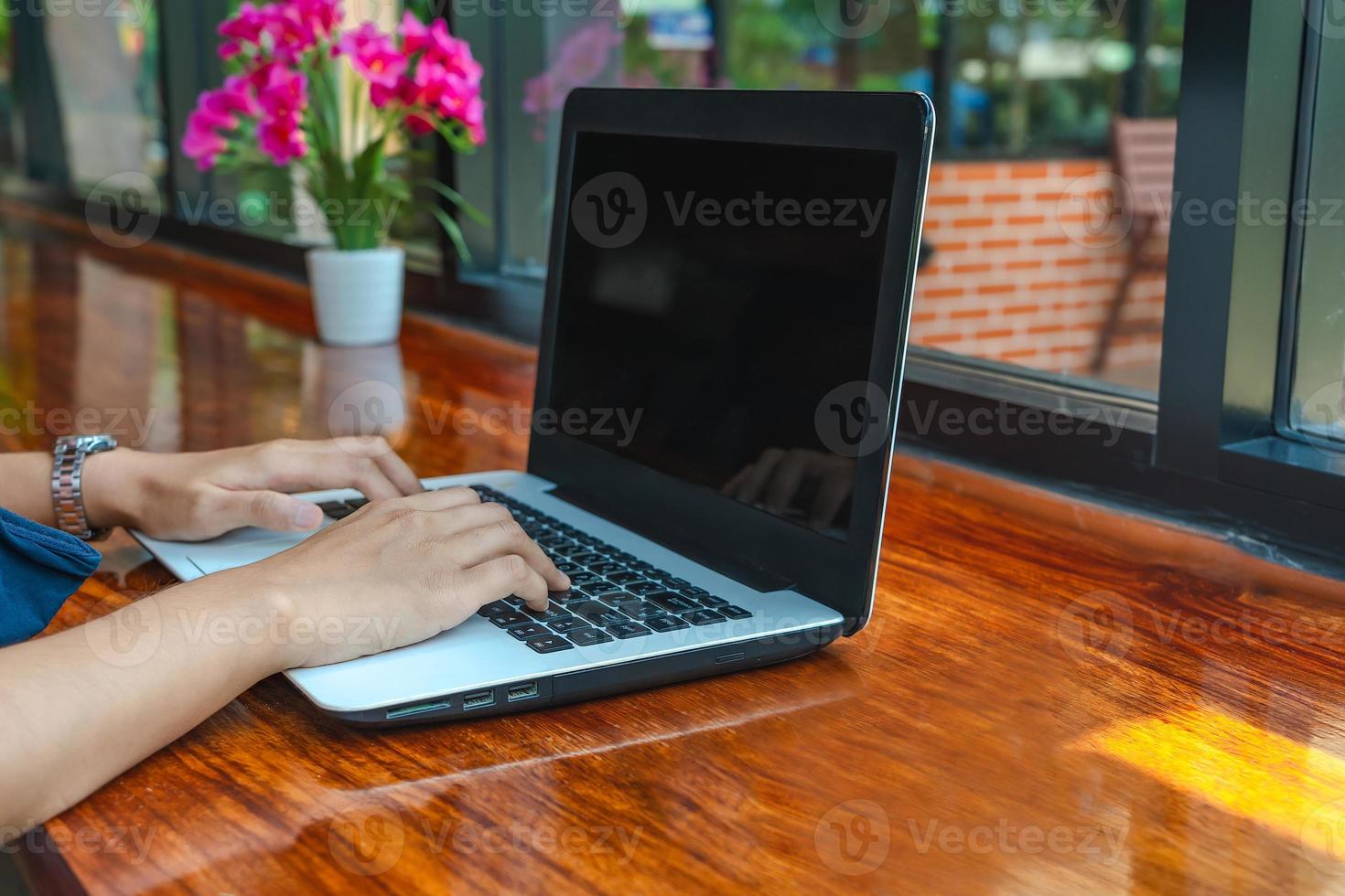 Close-up of female hands typing on a laptop keyboard at the coffee shop. Female hands working on a laptop, technology, freelance, online course, remote work, internet concept. photo