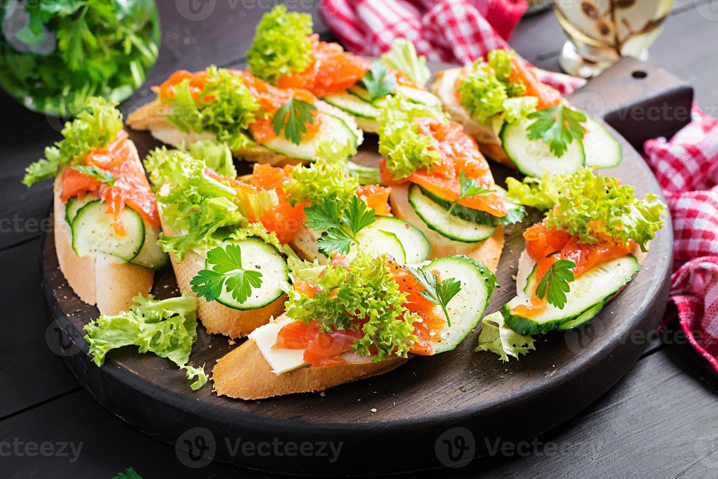 Tapas.  Salted Salmon, butter and cucumber toast sandwiches on wooden board. photo