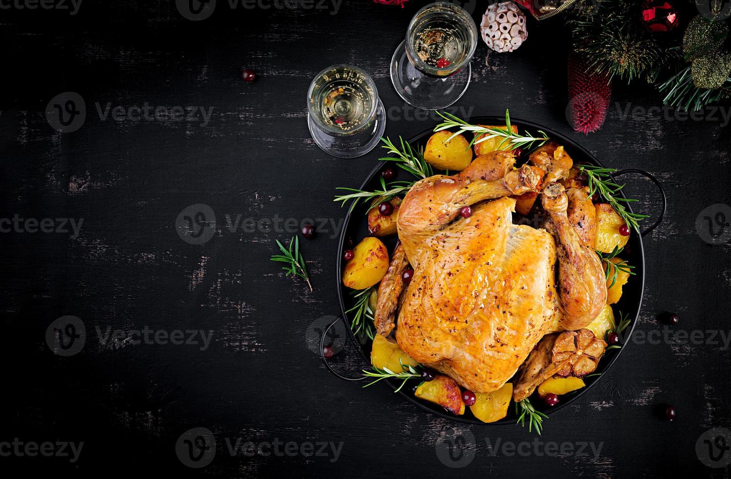Baked turkey or chicken. The Christmas table is served with a turkey, decorated with bright tinsel. Fried chicken. Table setting. Christmas dinner. Top view photo
