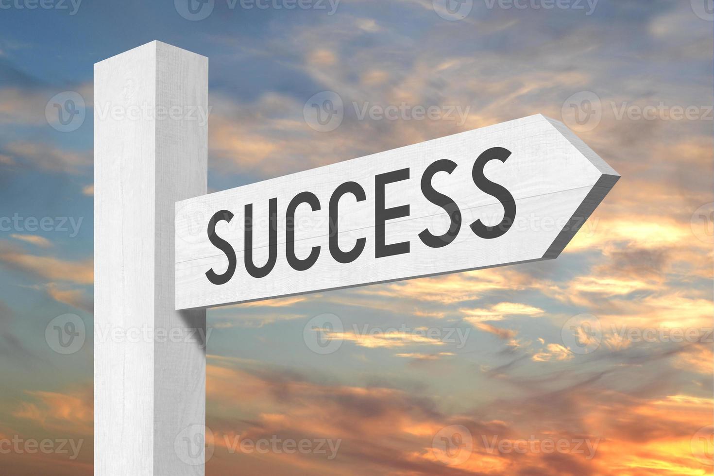 Success - White Wooden Signpost with one Arrow and Sunset Sky in Background photo