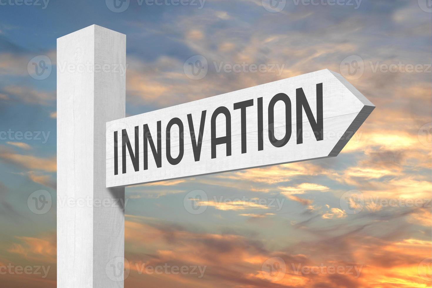 Innovation - White Wooden Signpost with one Arrow and Sunset Sky in Background photo