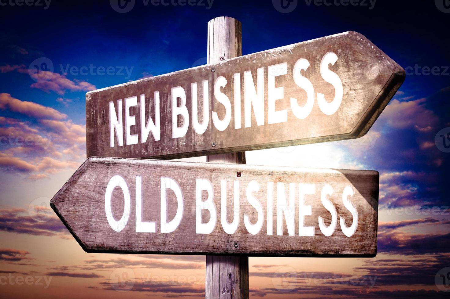 Old, New Business - Wooden Signpost with Two Arrows, Sunset Sky in Background photo