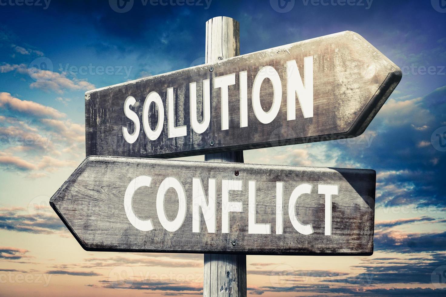Solution, Conflict - Wooden Signpost with Two Arrows, Sunset Sky in Background photo