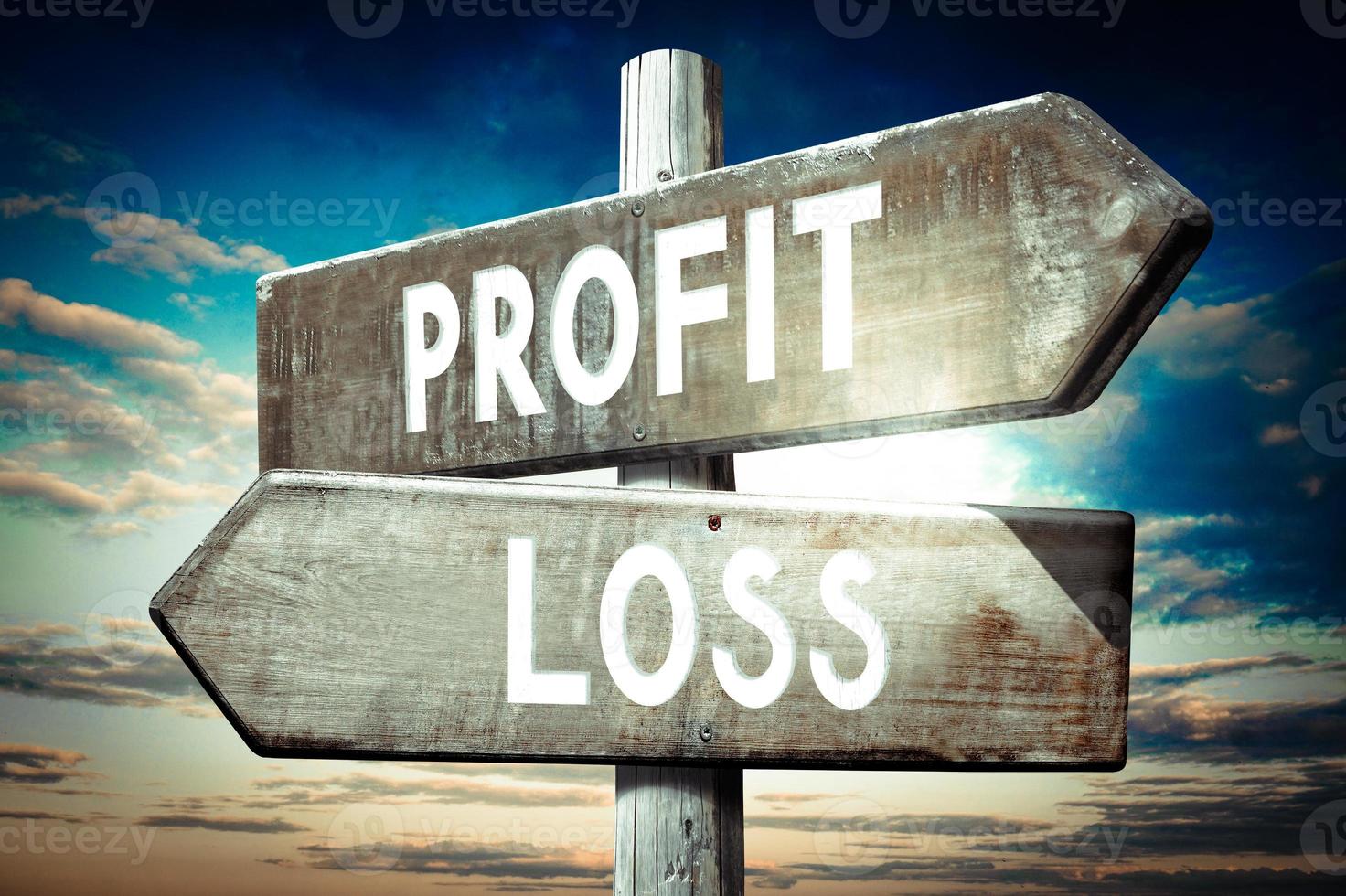 Profit, Loss - Wooden Signpost with Two Arrows, Sunset Sky in Background photo