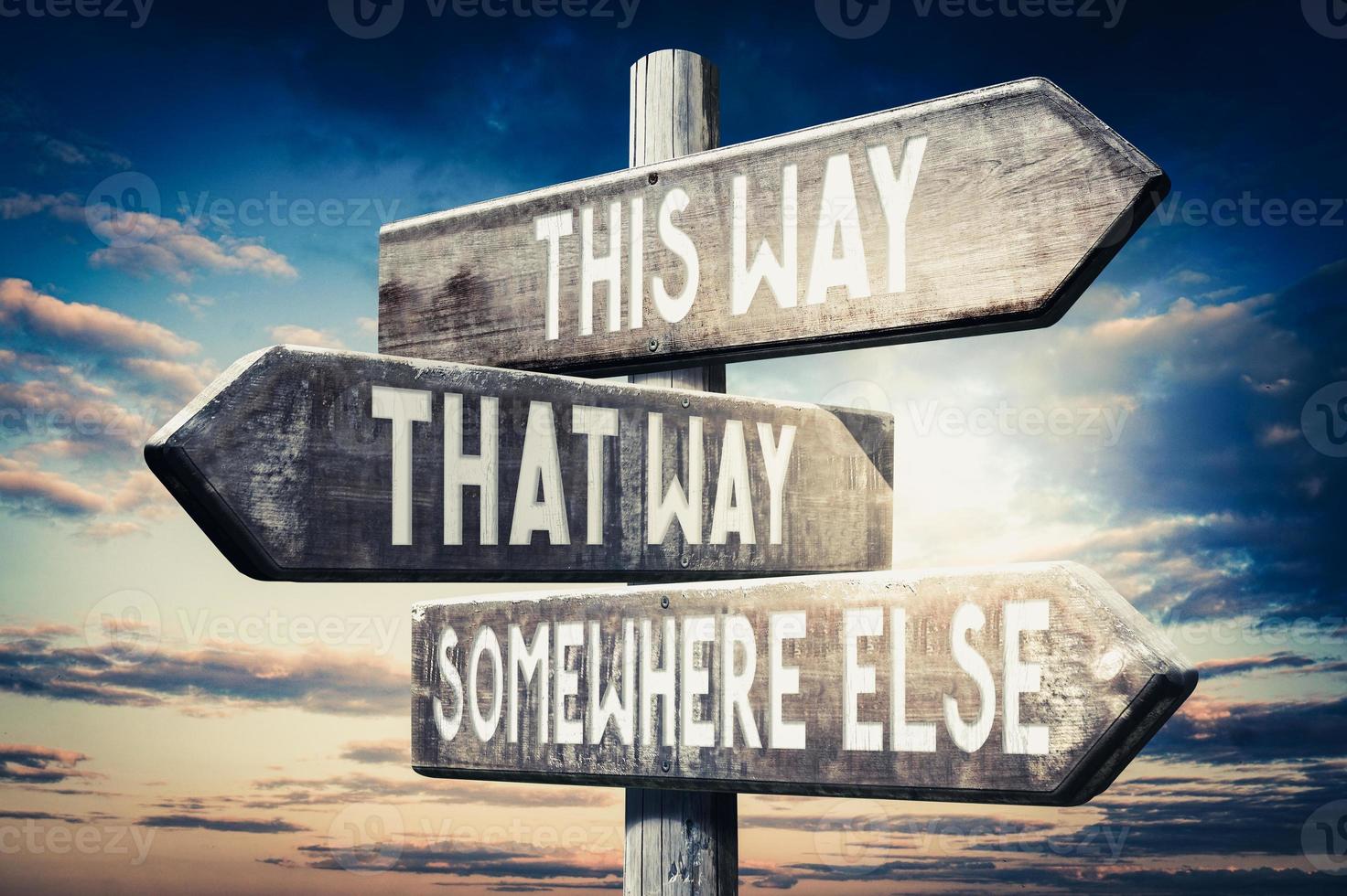This Way, That Way, Somewhere Else - Wooden Signpost with Three Arrows, Sunset Sky in Background photo