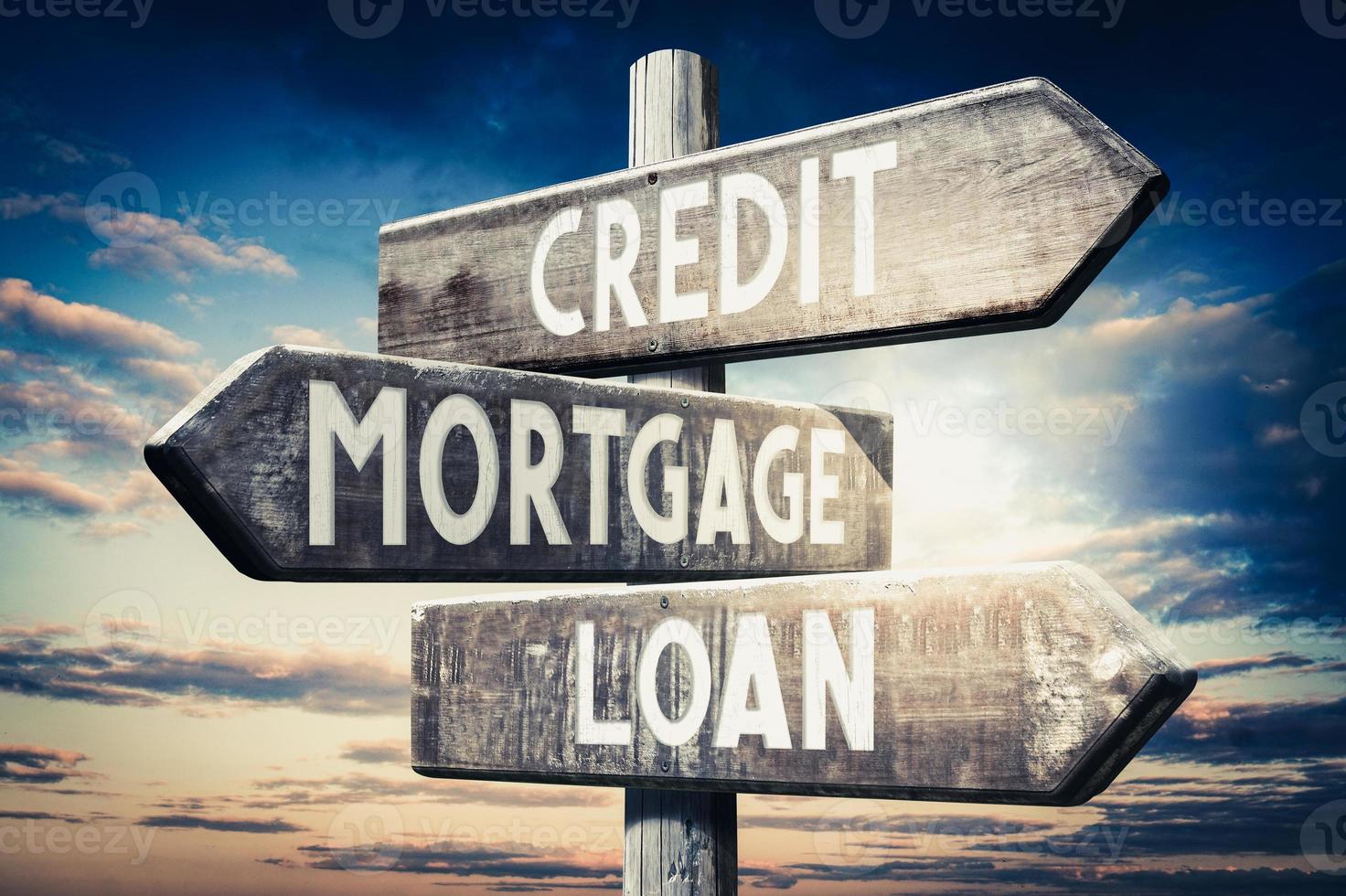 Credit, Mortgage, Loan - Wooden Signpost with Three Arrows, Sunset Sky in Background photo