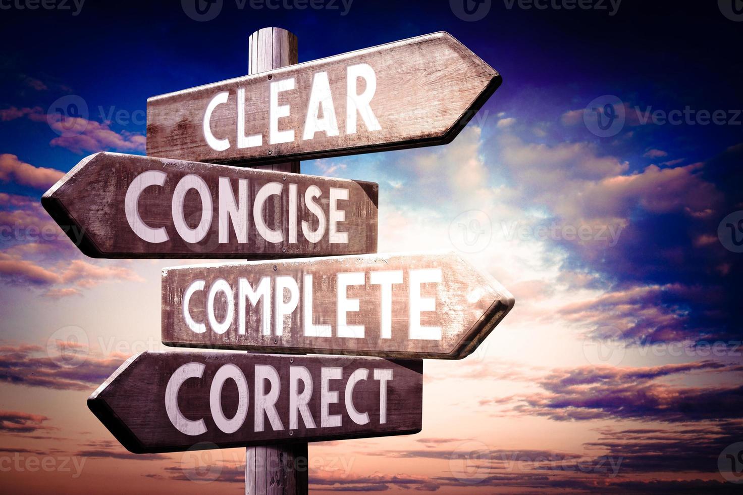 Clear, Concise, Complete, Correct - Wooden Signpost with Four Arrows, Sunset Sky in Background photo