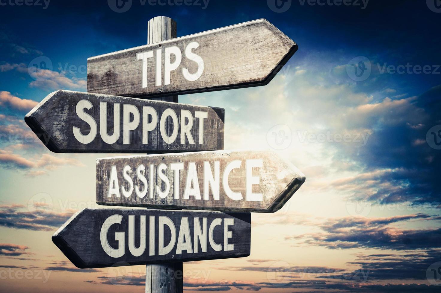 Tips, Support, Assistance, Guidance - Wooden Signpost with Four Arrows, Sunset Sky in Background photo