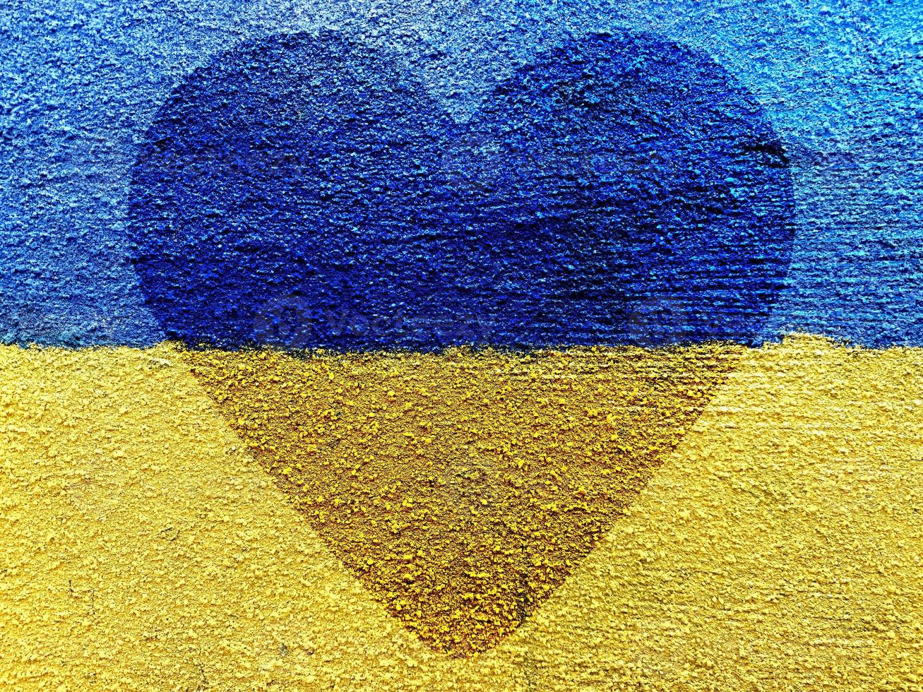 heart on Ukrainian flag painted on stone wall photo