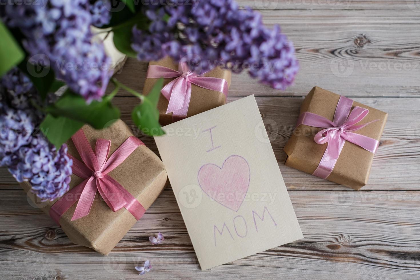 A bouquet of lilacs and a card with the text I love mom. Mother's day concept photo