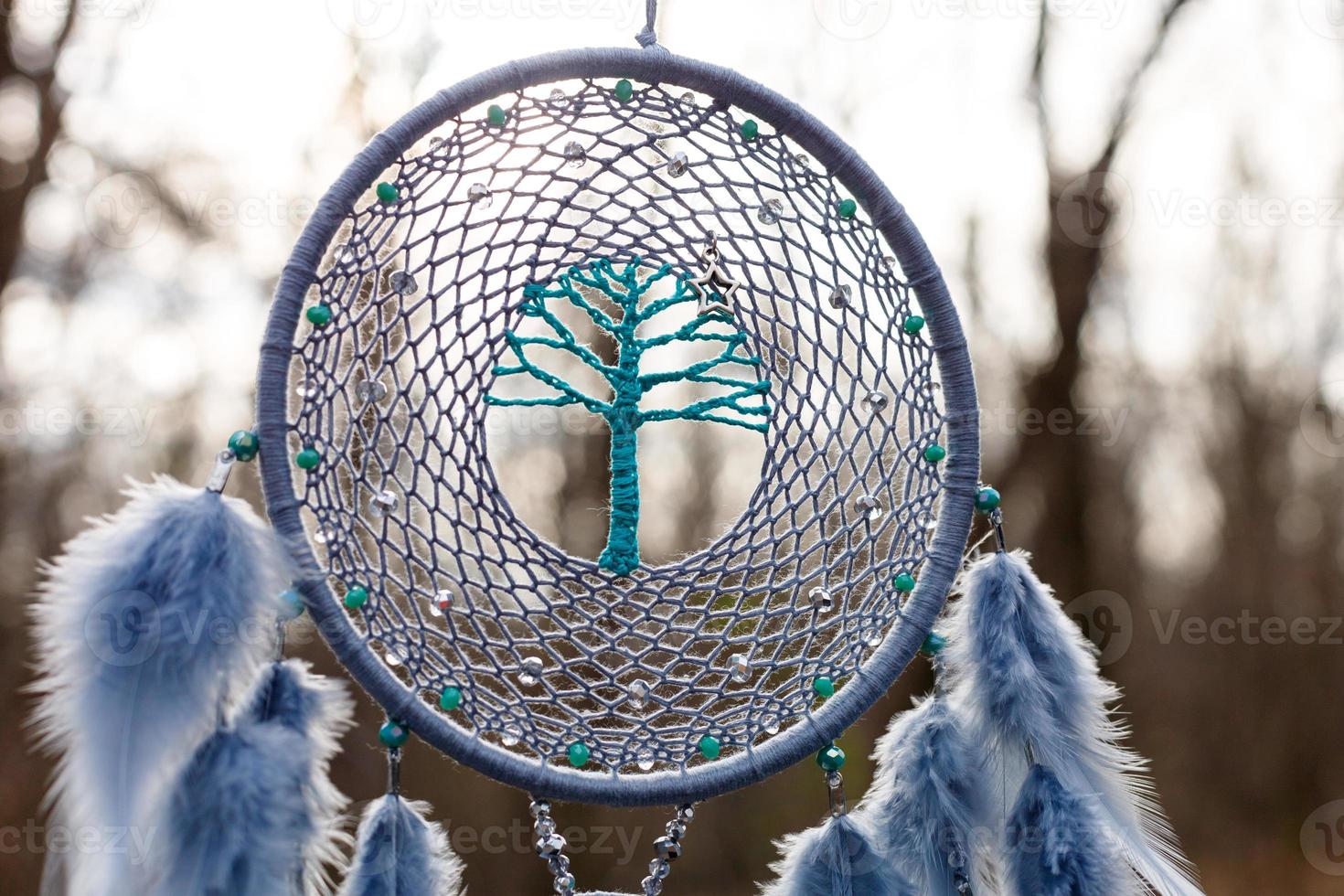 atrapasueños hecho a mano con hilos de plumas y cuerda de cuentas colgando foto