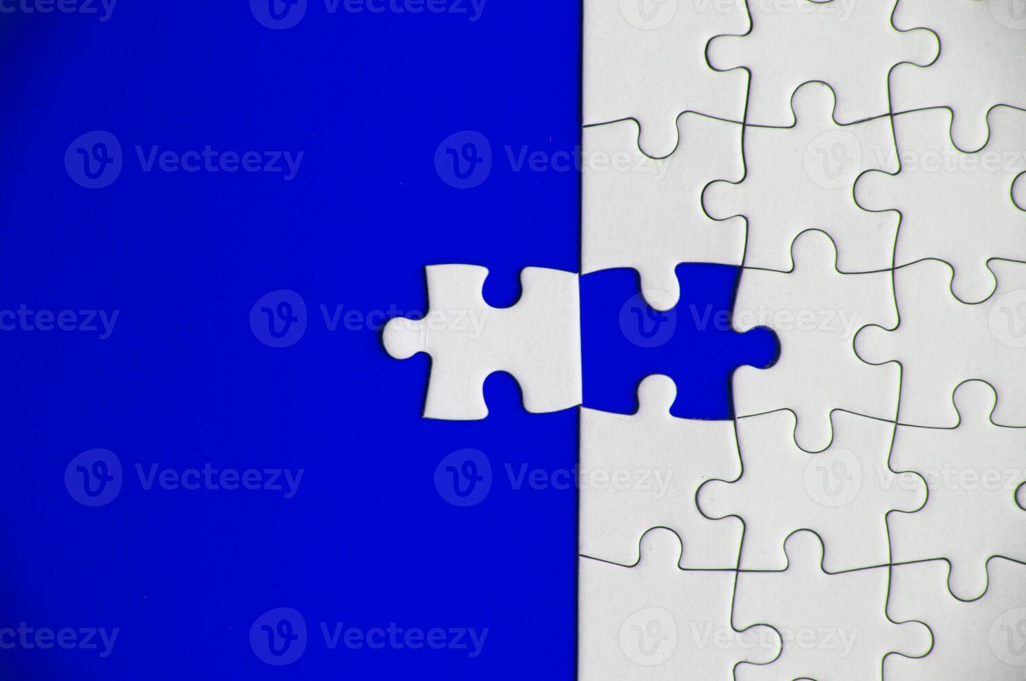 Top view of missing jigsaw puzzle on blue cover background. Copy space photo
