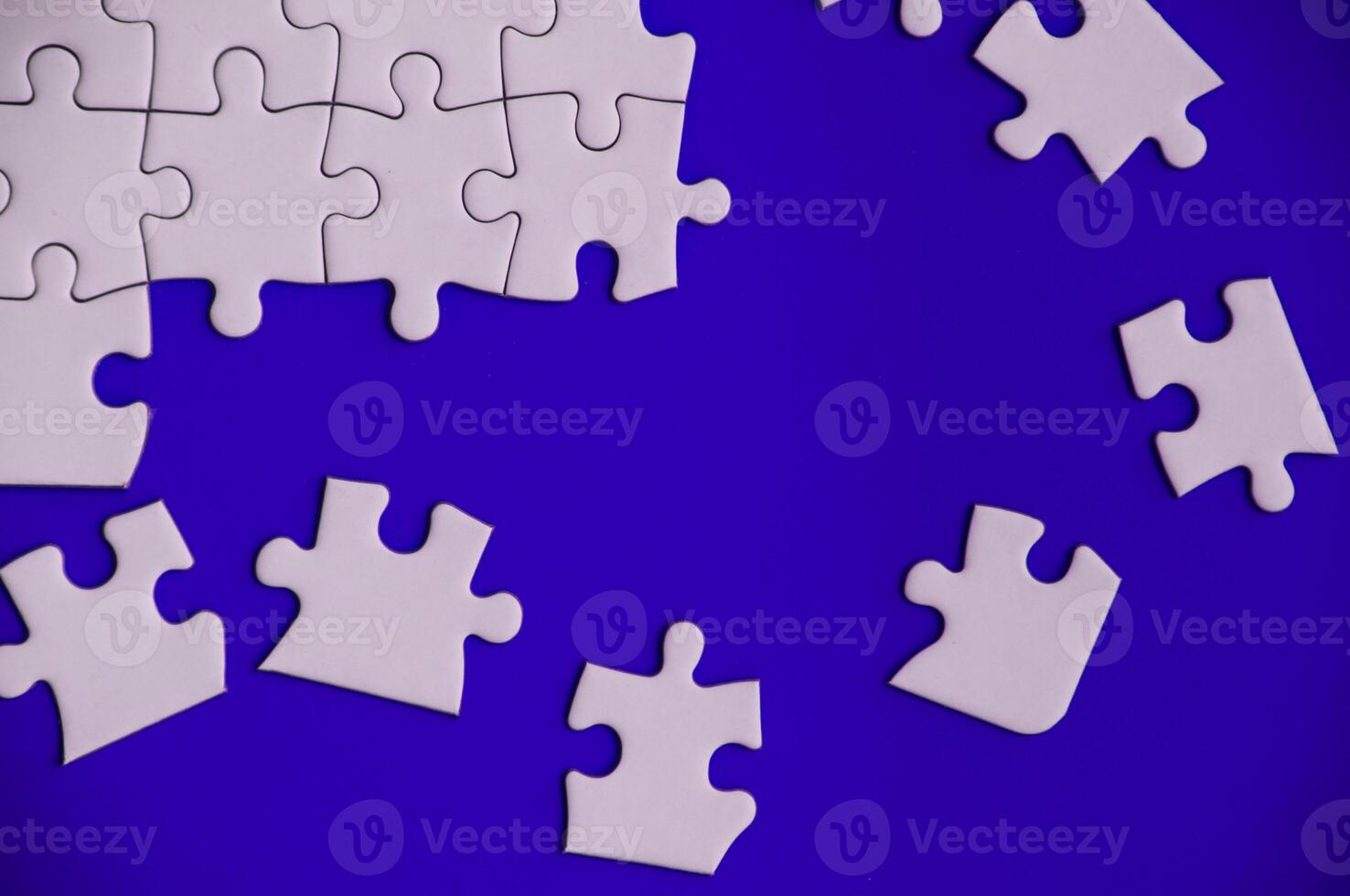 Top view of missing jigsaw puzzle on blue cover background. Copy space. photo