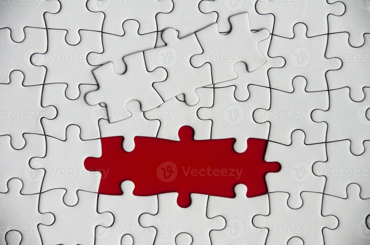 Top view of missing jigsaw puzzle on red cover background. Copy space photo