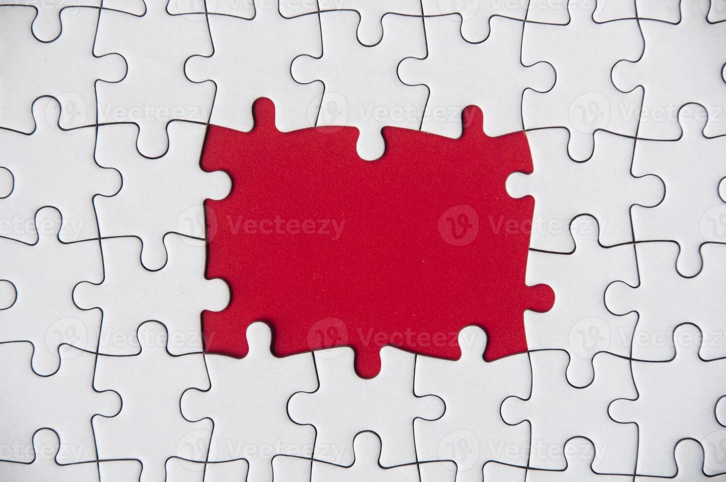 Top view of missing jigsaw puzzle on red cover background. Copy space photo