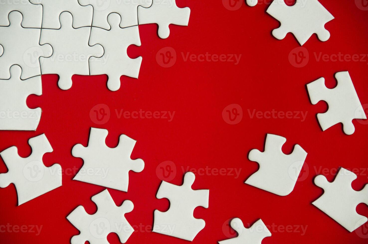 Top view of missing jigsaw puzzle on red cover background. Copy space photo