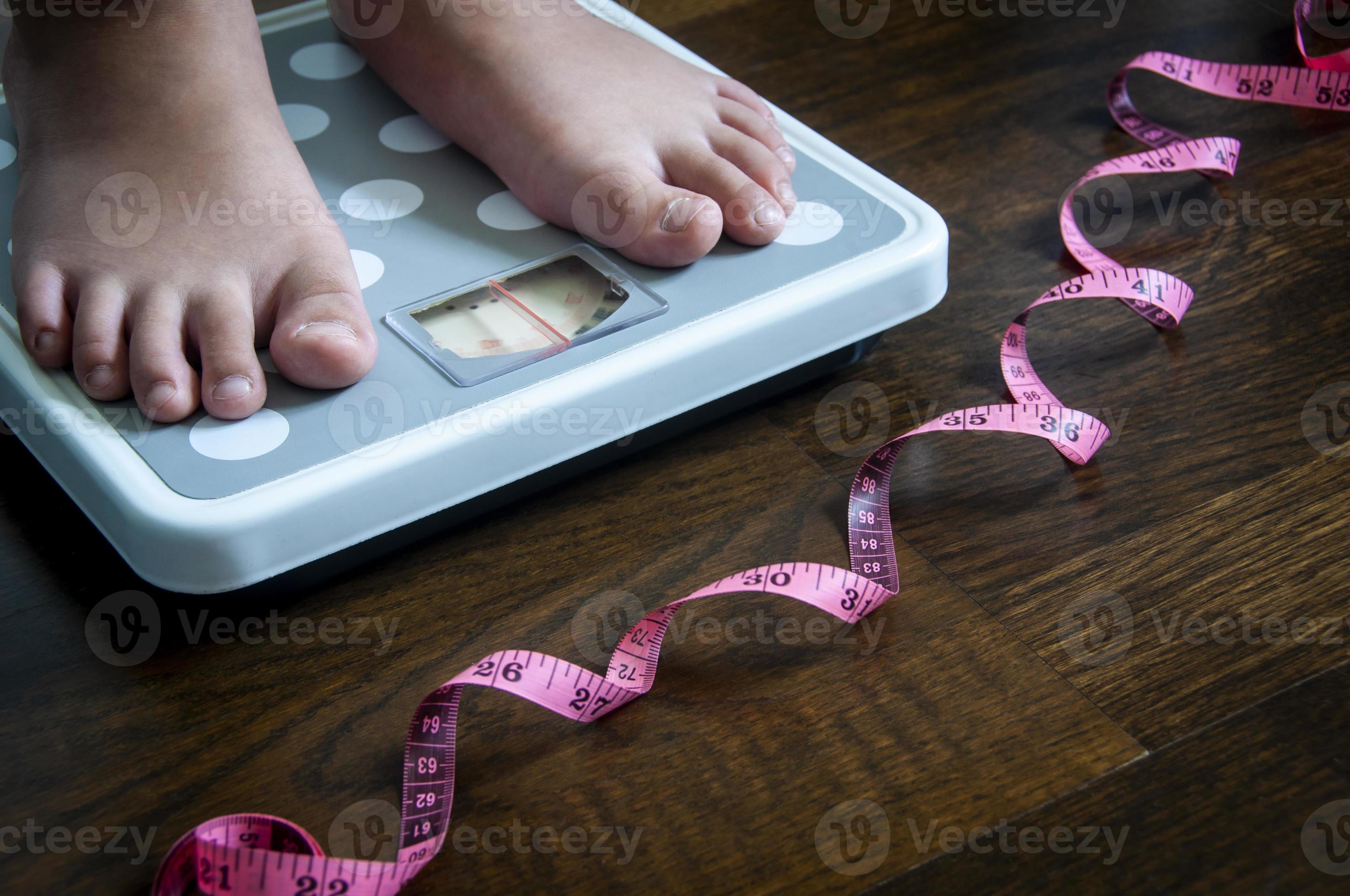 https://static.vecteezy.com/system/resources/previews/021/682/030/large_2x/side-view-of-measuring-tape-and-feet-on-weight-scale-weight-loss-concept-photo.jpg