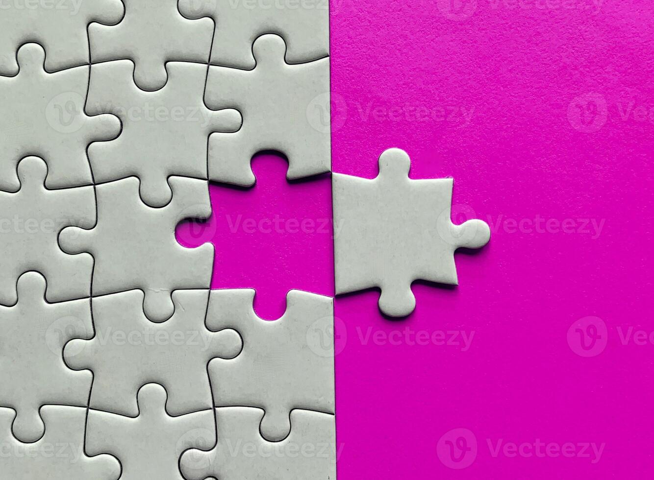 Top view of missing jigsaw puzzle with customizable space for text on pink color background. Copy space concept. photo