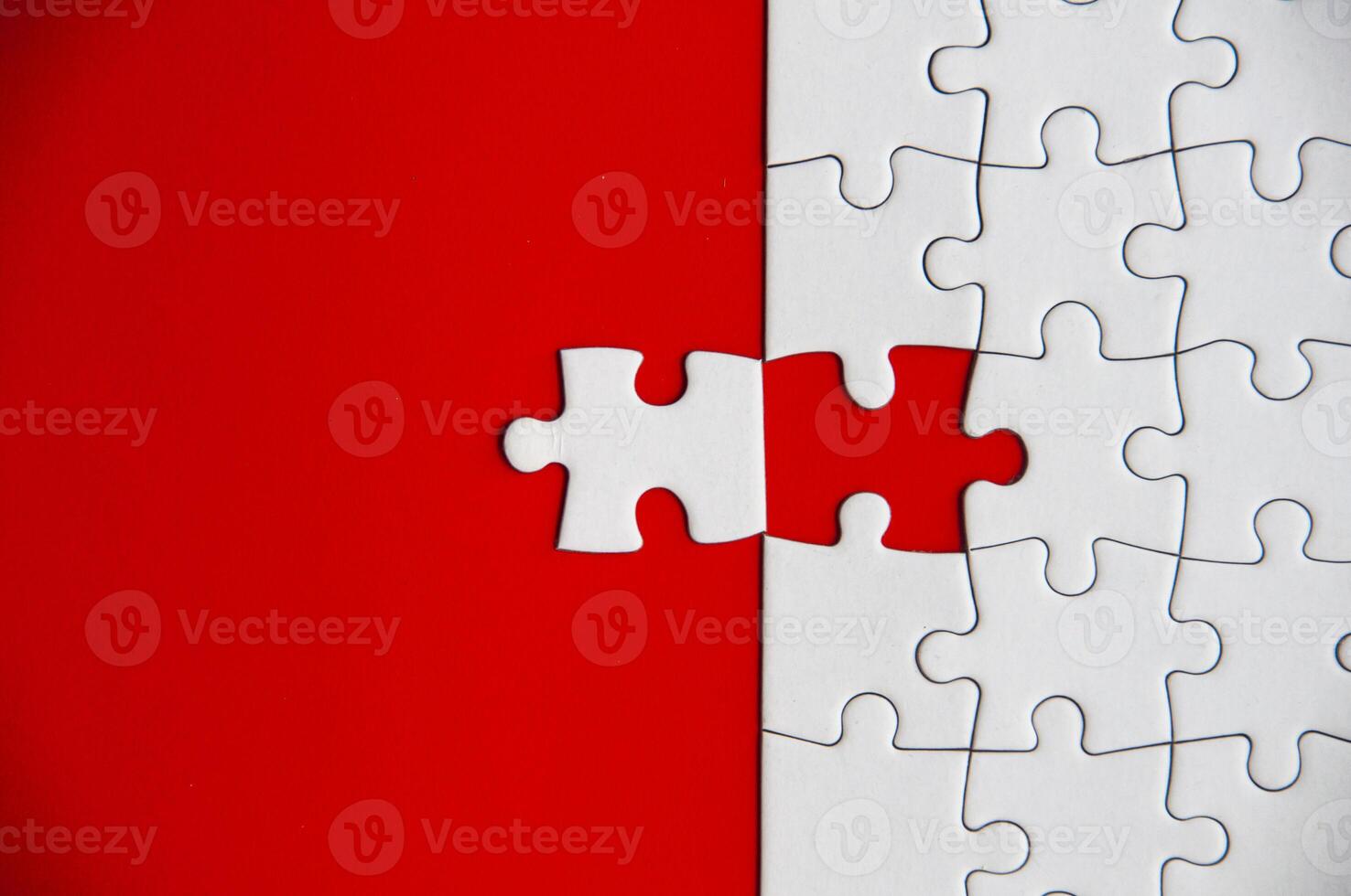 Top view of missing jigsaw puzzle on red cover background. Copy space photo