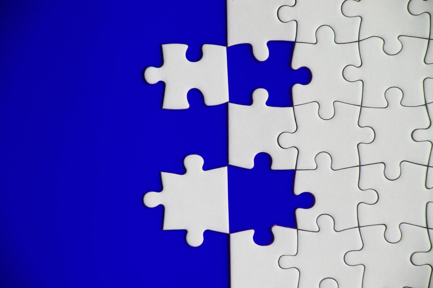 Top view of separated jigsaw puzzle on blue cover background. Copy spave photo