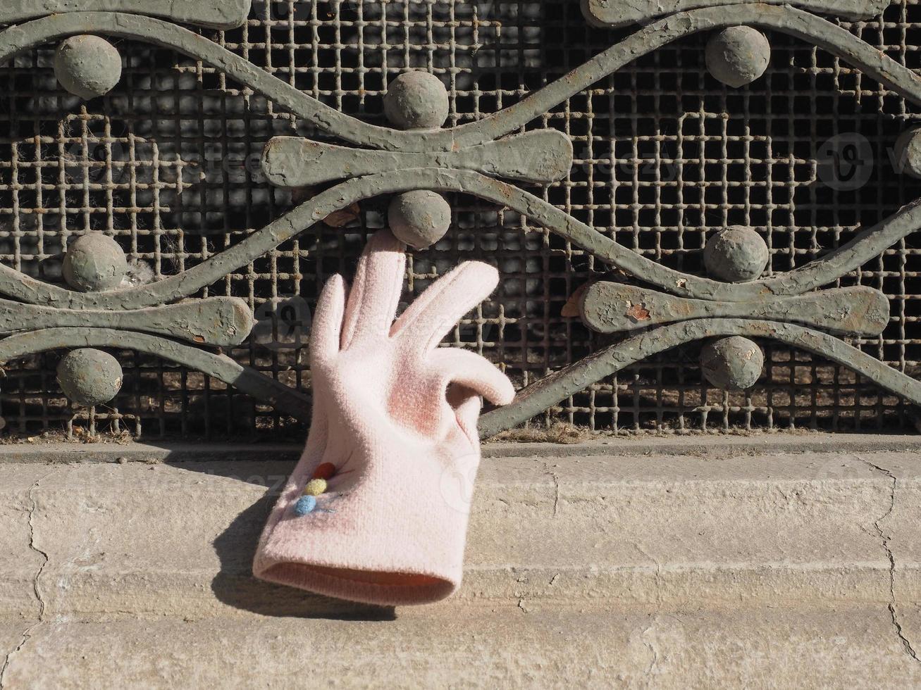 pink glove on window grate photo