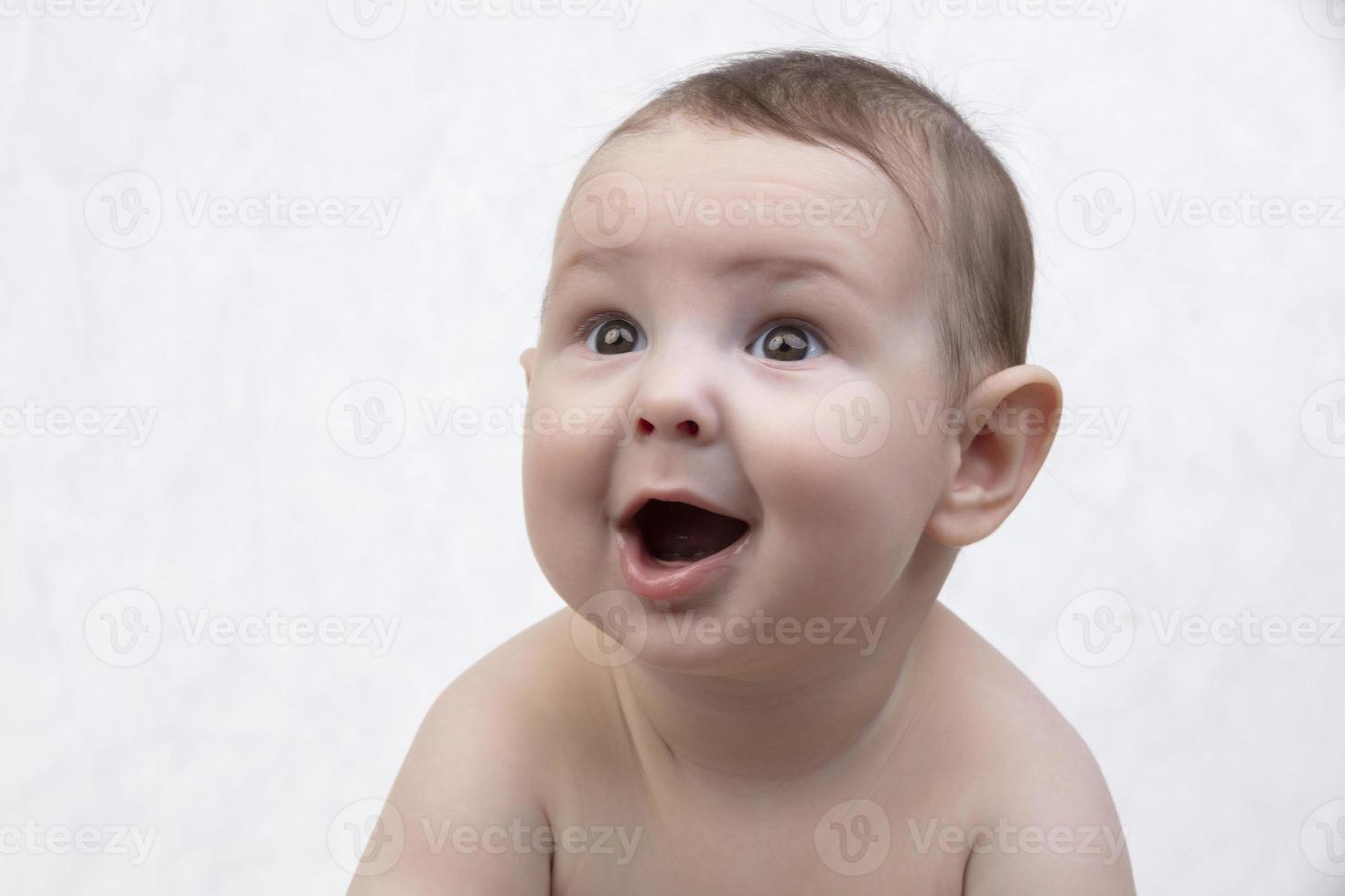 Surprised child's face. Portrait of a newborn baby with a funny shocked expression. Emotion admiration. photo