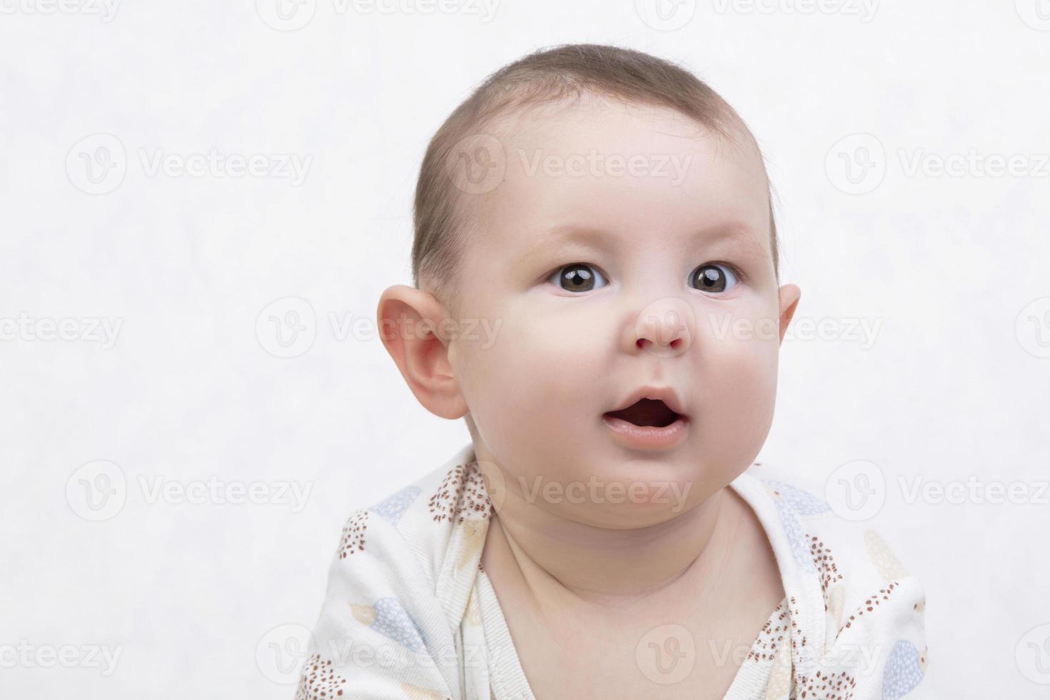 Six month old baby on a white background. Happy boy mid-range. Conceptual photo of fatherhood and motherhood.Alpha generation.