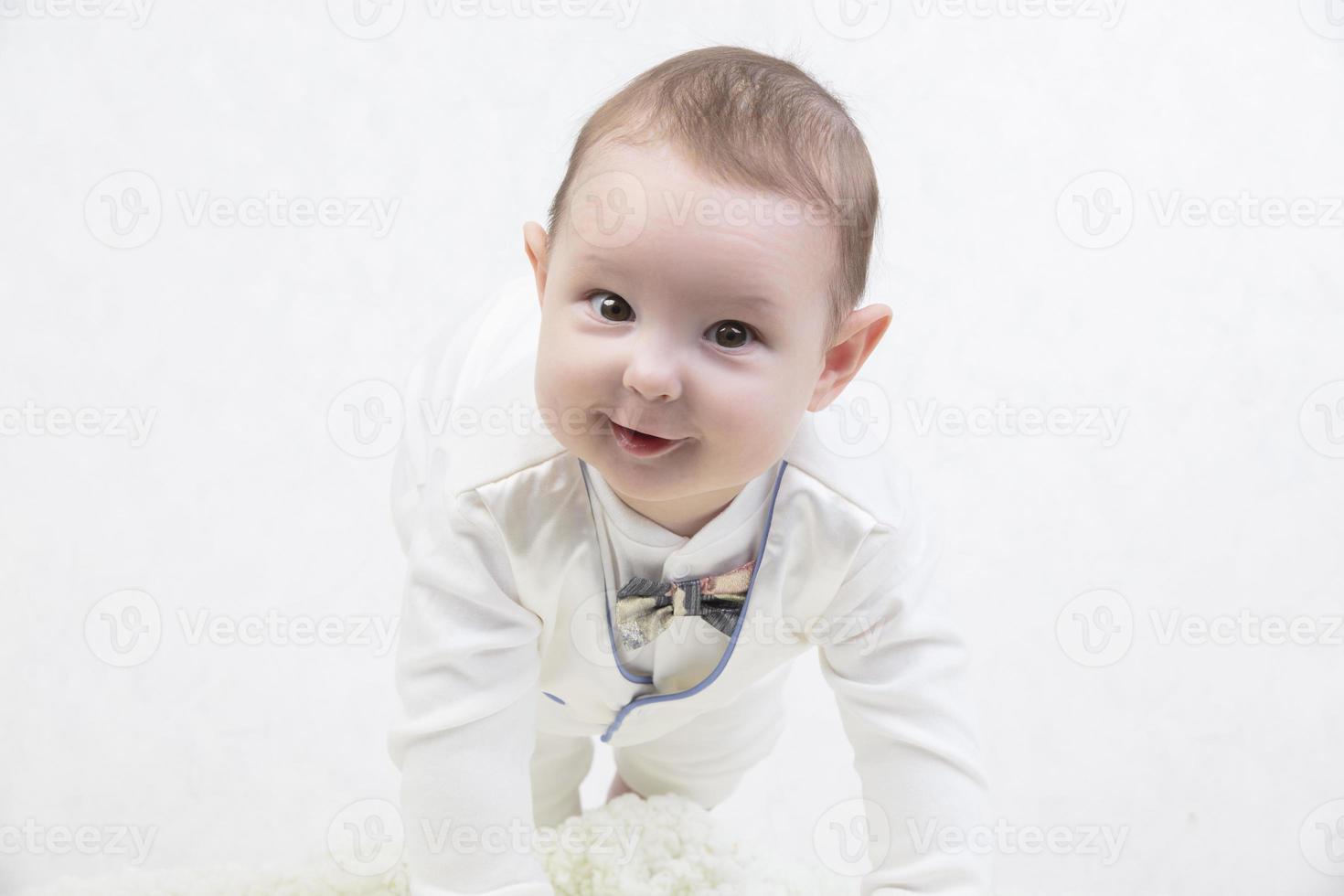 A smile on a child's face. Portrait of a six month old boy with a funny sly expression on his face. Generation Alpha. The concept of motherhood and fatherhood. photo