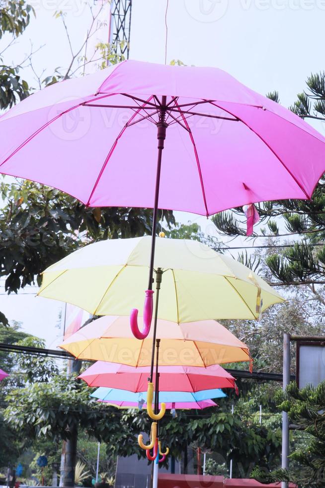 vistoso paraguas colgando encima calle de el parque. foto