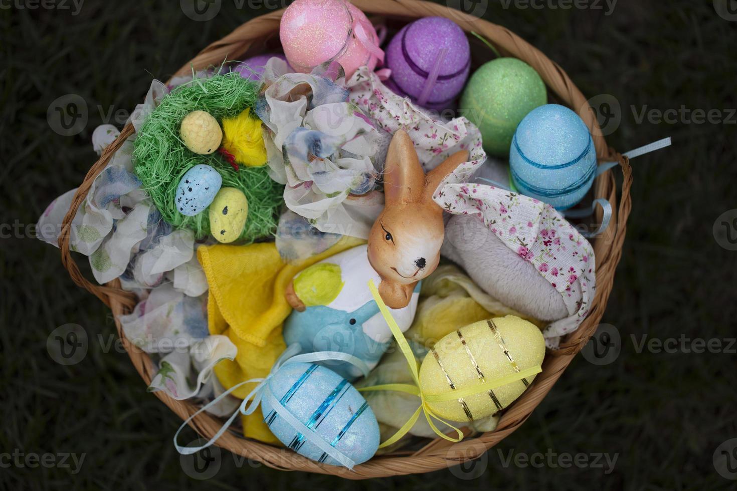 Easter basket with decorative eggs and bunny figurine. photo