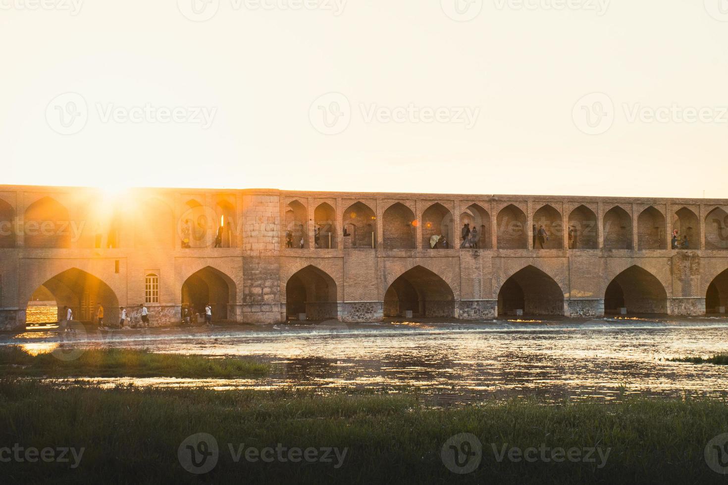 Isfahan, Iran,  2022 - people chill and socialize around SioSe Pol or Bridge of 33 arches, one of the oldest bridges of Esfahan and longest bridge on Zayandeh River photo