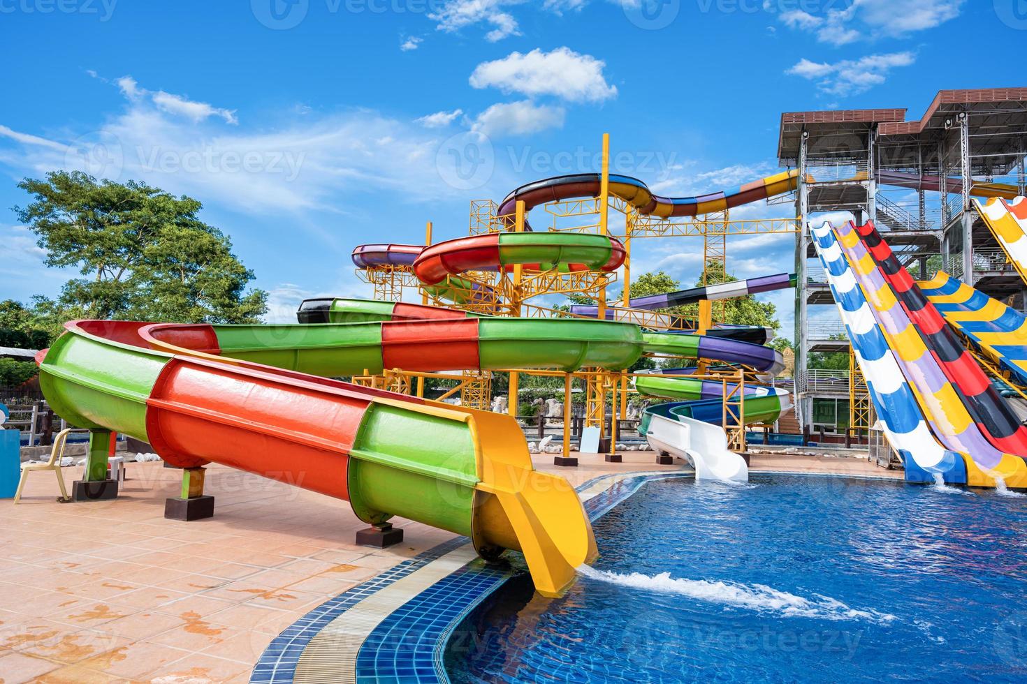 Swimming pool with water slides in aqua park on sunny day. summer fun activity, vacation leisure concept. photo